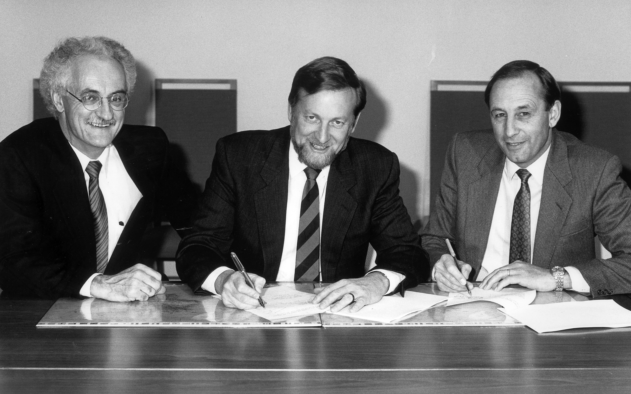 Bill Armstrong (right) signing a volunteer program agreement with Foreign Minister Garath Evans (centre) and Christopher Fogarty, former Chair of OSB/AVI.