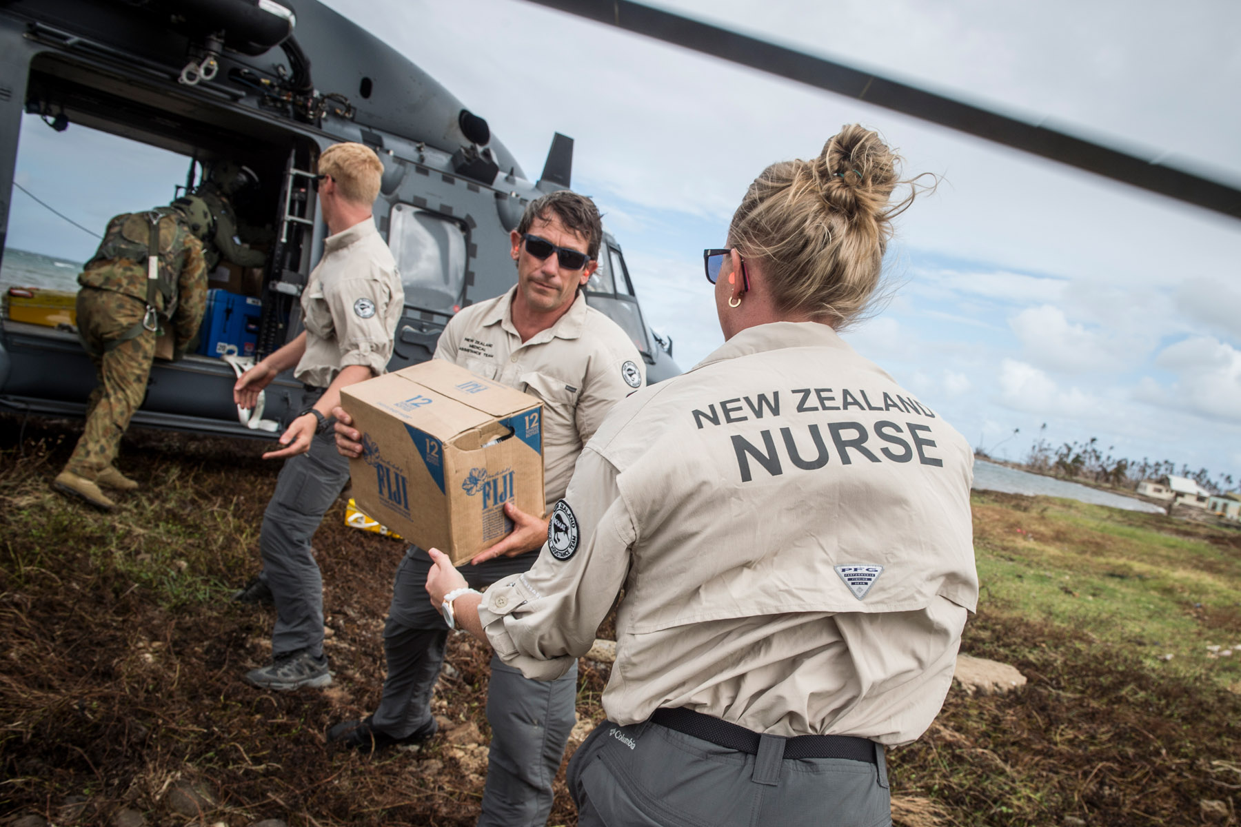 Members of NZ Medical Assistance Team help unload aid and equipment in Nasau, Koro Island following Tropical Cyclone Winston (image: NZDF / NZ MFAT)