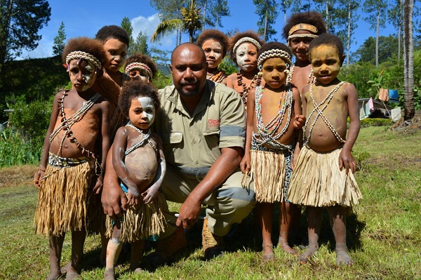 Children with Digicel Foundation Project Manager, Mr Haro Gomara, at the Sambio Rural Health Aid Post launch in remote Menyamya District, Morobe Province