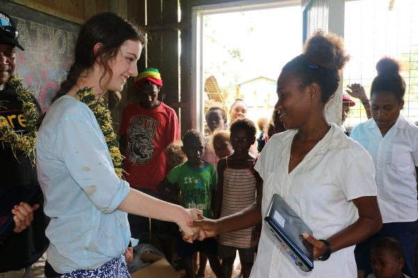 Grace presenting one of the donated laptops to the Head Girl of the One One Village Primary School, Malaita Province