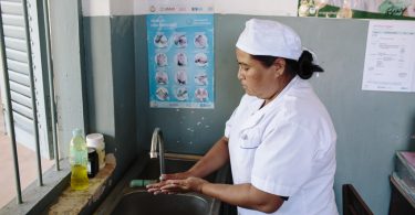 Midwife washes her hands at a sink, Cambodia (Photo credit: WaterAid/Tom Greenwood)
