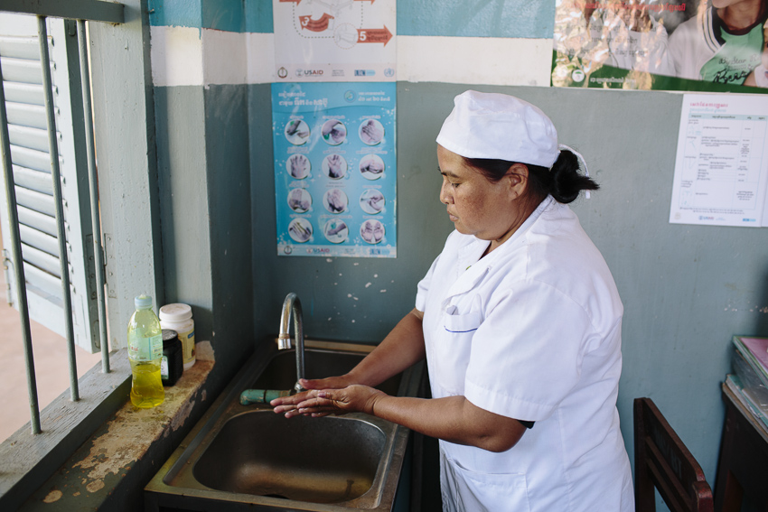 Midwife washes her hands at a sink, Cambodia (Photo credit: WaterAid/Tom Greenwood)