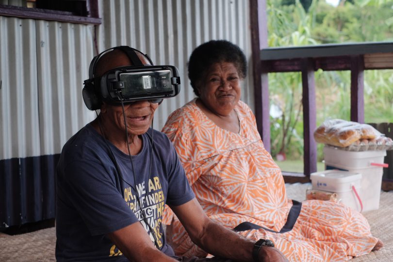 75-year old Rupeni Vatugata, with his wife Losena, watches their story unfold in 360-degree virtual reality (Credit: Tom Perry/World Bank)