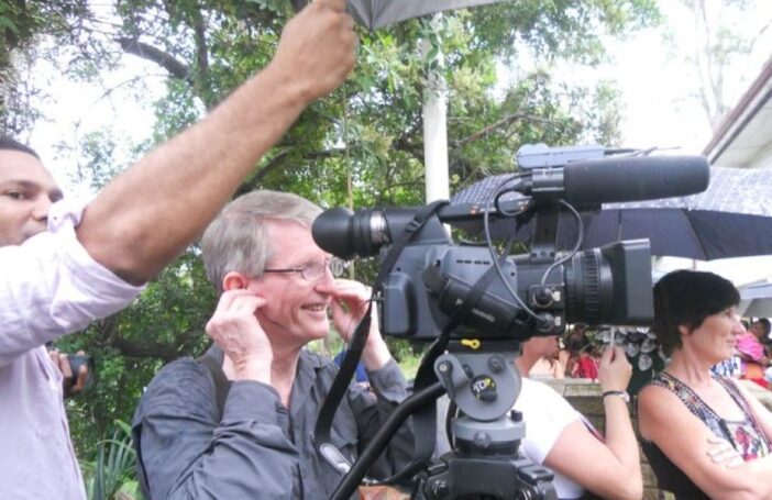 Sean Dorney filming at the opening of Jocelin Leahy's Pacific Art studio in 2014 (Credit: ABC)