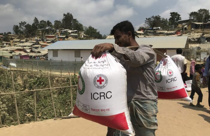 Man carrying two ICRC BRCS food bags (ICRC)