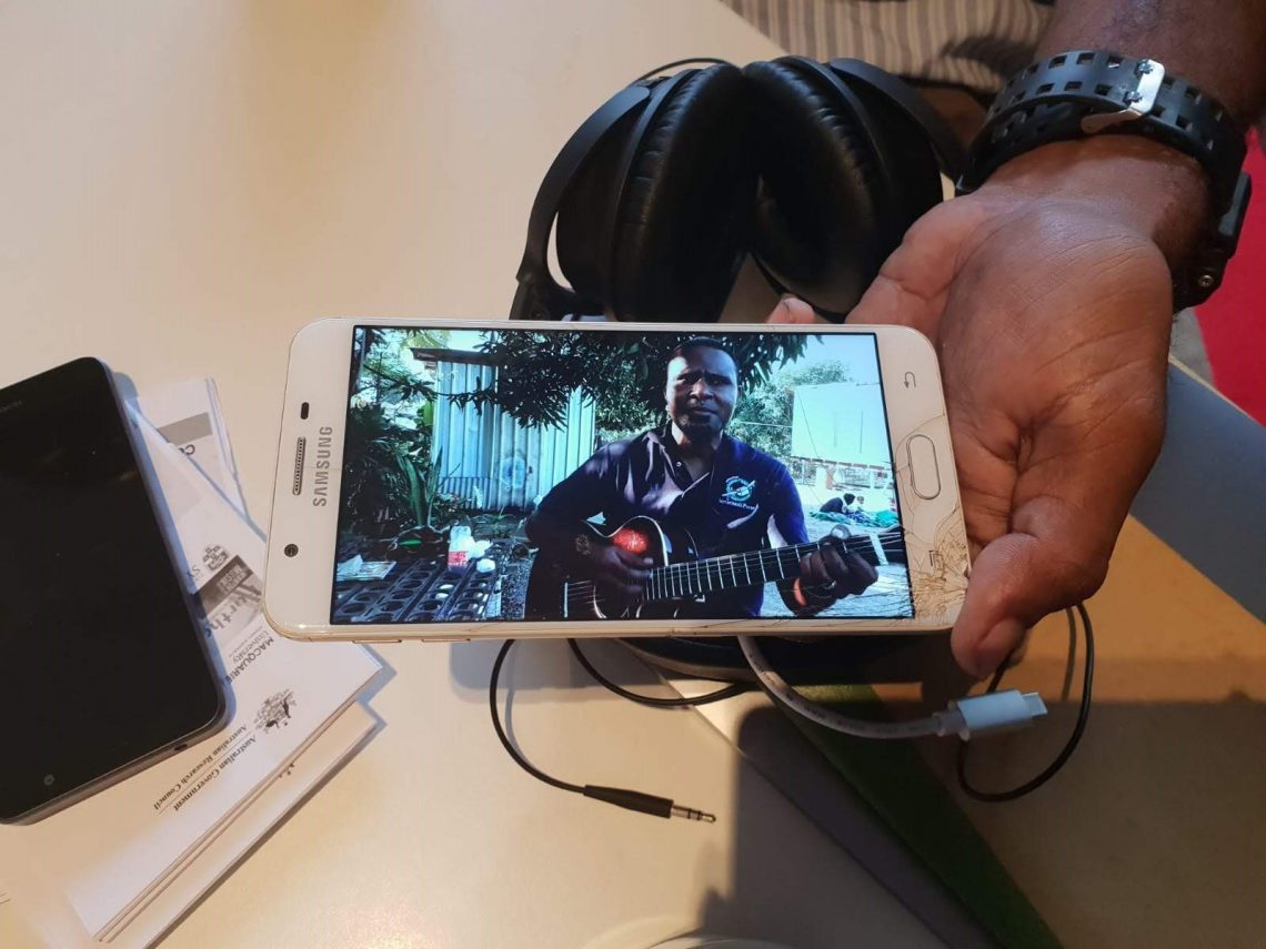 A local guitarist on a mobile telephone screen, Irupara village, Central Province, PNG, 2019 (Denis Crowdy)
