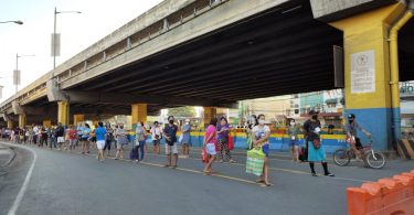 People keeping distance before entering the public market in Muntinlupa City, Philippines (ILO Asia-Pacific/Flickr CC BY-NC-ND 2.0)