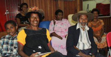 Third-born daughter, Nancy Kumanyal (in PNG meri blouse and hat), and Nepe Kumanyal (in Akubra hat) with other family members in the PNG National Museum Theatrette, August 2015.