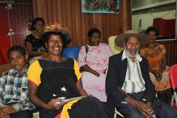 Third-born daughter, Nancy Kumanyal (in PNG meri blouse and hat), and Nepe Kumanyal (in Akubra hat) with other family members in the PNG National Museum Theatrette, August 2015.