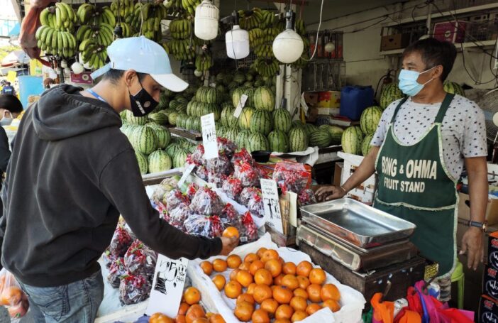 A customer and fruit seller keeping distance in the market, Manila (ILO Asia-Pacific)