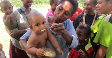 Child in Suabi Village, PNG, enjoying nutritious corn porridge (Russ Stephenson)