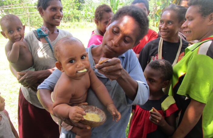 Child in Suabi Village, PNG, enjoying nutritious corn porridge (Russ Stephenson)