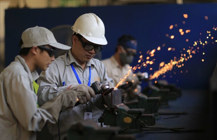 Photograph of migrant workers learning metal fabrication skills