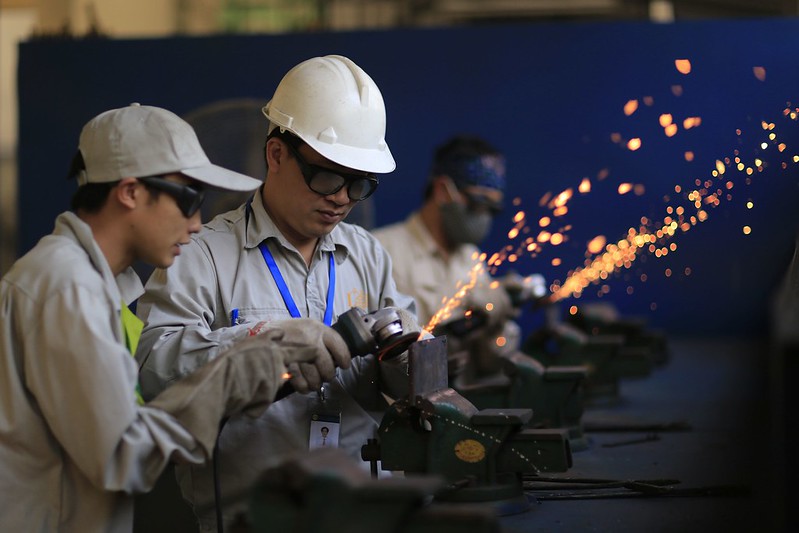 Photograph of migrant workers learning metal fabrication skills