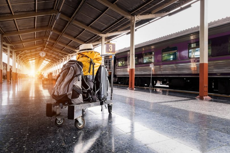 Photography of backpacks on a luggage trolley on a train stations platform.