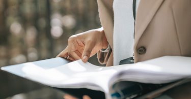 Cropped photo of hands holding a binder of paperwork