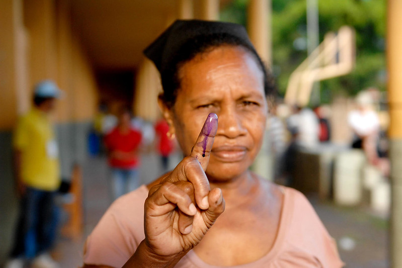A woman holds up her stained finger after voting today in Timor-Leste's presidential run-off poll on 2012