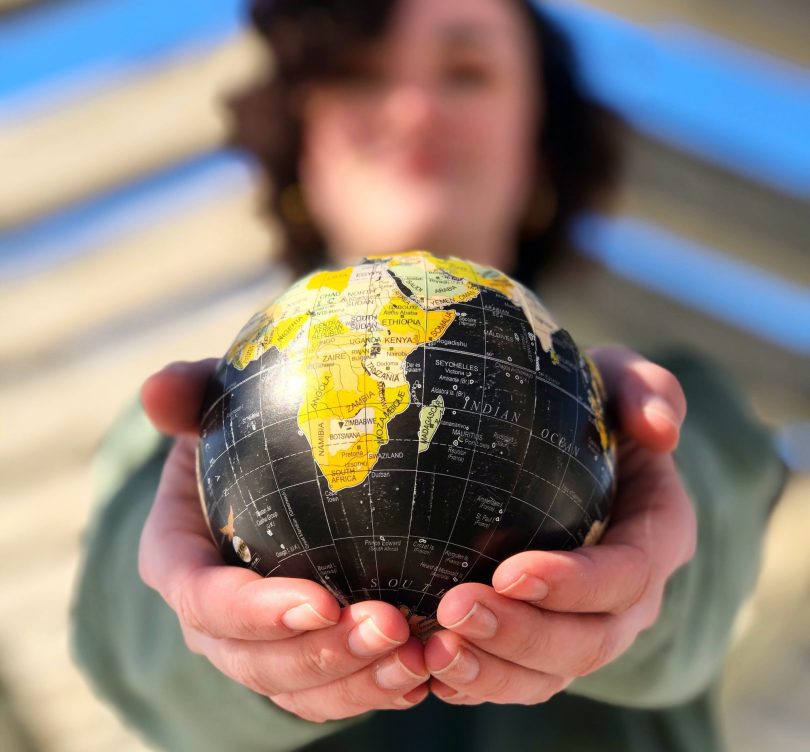 A person holding a globe.