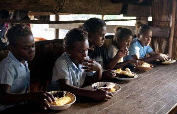 Fiona, 18, eating breakfast with her siblings inside their home in a community affected by rising sea levels in Malaita Province, the Solomon Islands. (2)