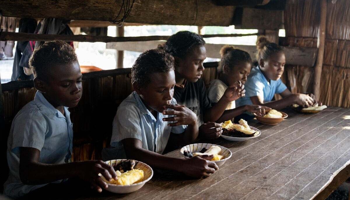 Fiona, 18, eating breakfast with her siblings inside their home in a community affected by rising sea levels in Malaita Province, the Solomon Islands. (2)