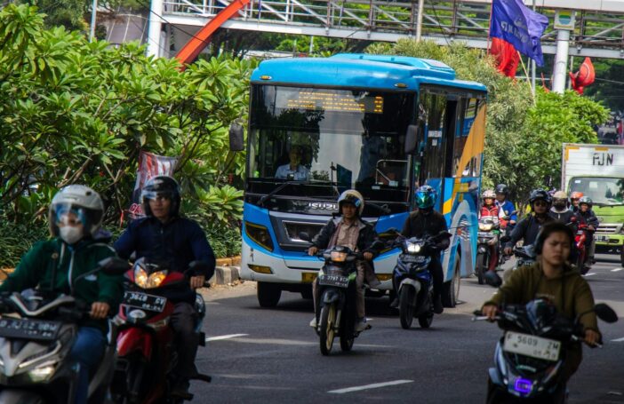 a group of people riding motorcycles down a street