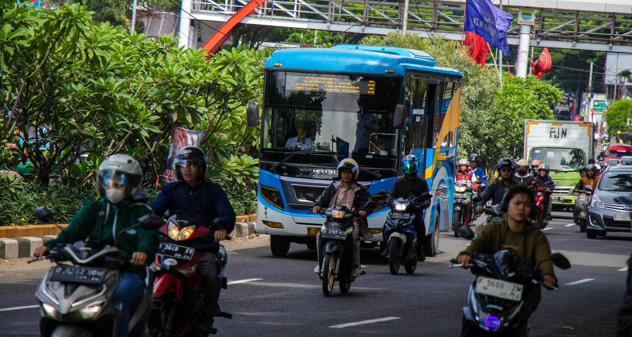 a group of people riding motorcycles down a street