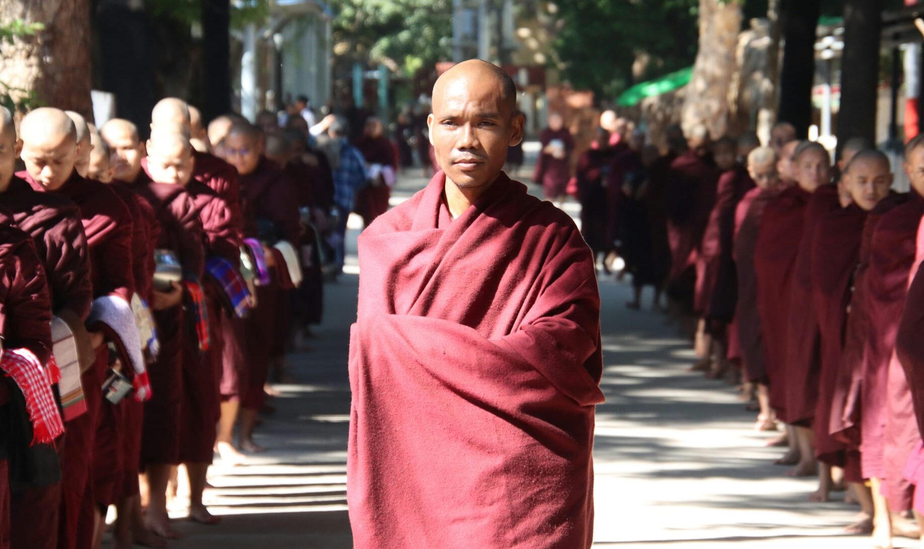 A group of buddhist monks in maroon robes walking