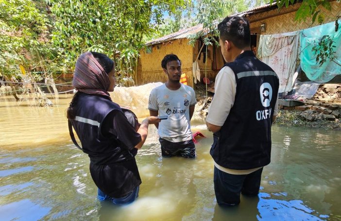 Members of Oxfam Bangladesh's Emergency Response Team talking with Rubayet in front of his damaged home